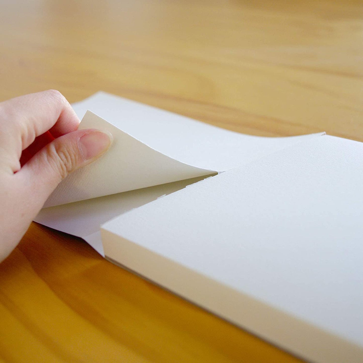 A person ripping out a page of paper from the A3 Pencilmarch student watercolour paper pad with 300 gsm paper and 30 pages - Stationery Island
